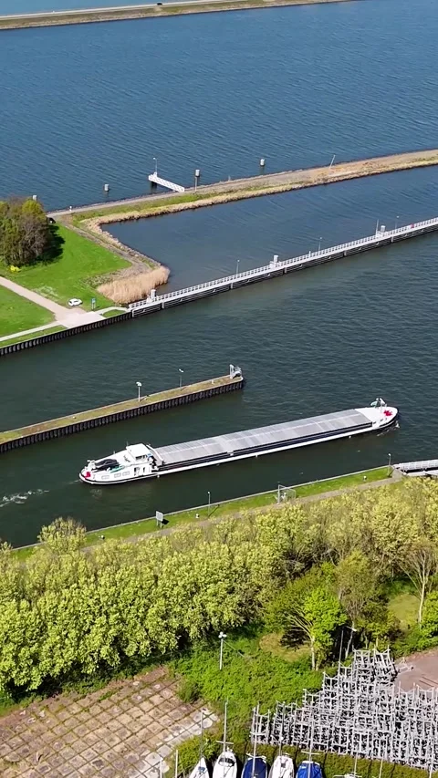 Aerial View Of Long Cargo Ship Navigating Through Water Lock System Видео 335476172