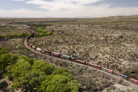 Aerial view of long container stack trains winding around curves Stock Photos