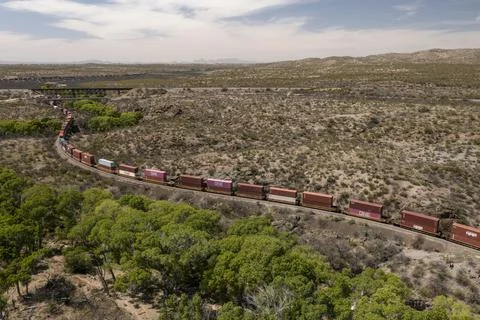 Aerial view of long container stack trains winding around curves Stock Photos