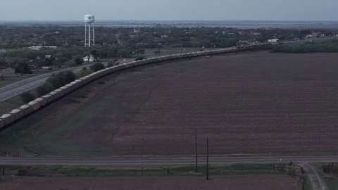 Aerial View of Long Freight Train Curving Through Small Texas Town Stock Footage 336479611