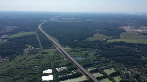 Aerial view of long highway through forest landscape Stock Footage 322956260