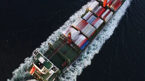 Aerial view of long massive cargo ship with containers sailing in the ocean Stock Footage 99886118