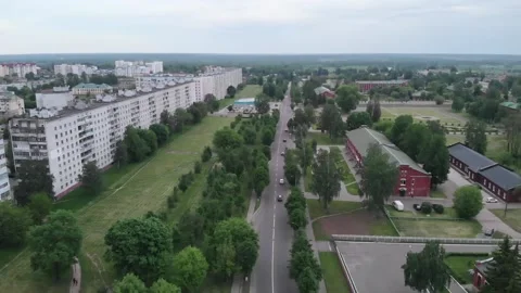 Aerial view of long multi-storey panel houses and city blocks among the trees 库存影片 157637683
