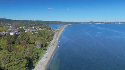 Aerial view of a long, narrow spit of land stretching out into the blue water Stock Footage 285996467