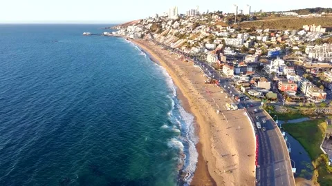 Aerial view of long sandy beach and coastal city at sunset Video stock 328174322