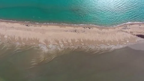 Aerial view of long thin sand tombolo separating turquoise sea - Sediment Drift Stock Footage 339392238