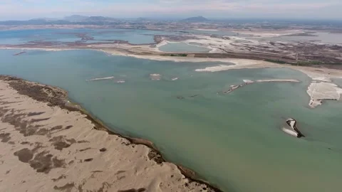 Aerial view of longshore drift shaping tombolo and sand bar between sea Stock Footage 339589543