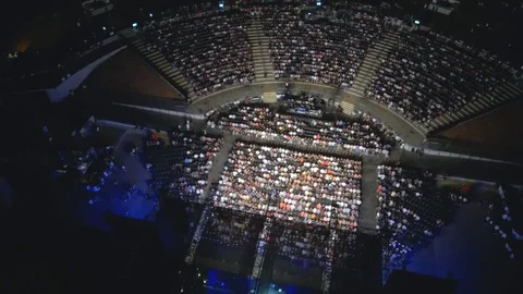 Aerial view, looking down on a packed stadium park during a live show in Stock Footage