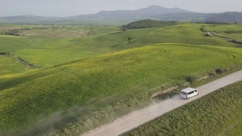 Aerial view looking down on a rural road in the Tuscany countryside with a car. Stock Footage 129453287