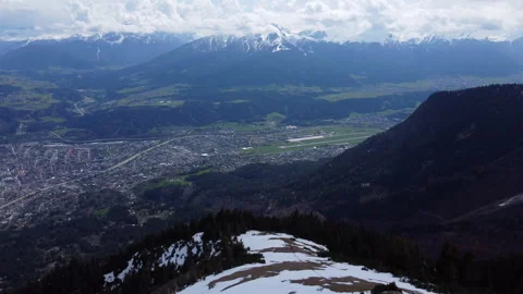 Aerial view looking down valley over city of Innsbruck and Nordkette snowy Stock-Footage 243975729