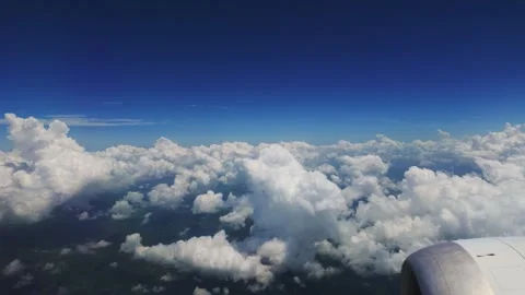 Aerial view looking out an airplane window over a vast blanket of fluffy white Stock Footage 346125251