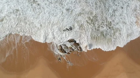 Aerial view looking straight down on white waves crashing on empty beach Stock Footage 95178762