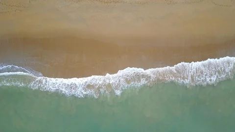 Aerial view of looping ocean wave reaching the coastline. Summer tropical beach Stock Footage