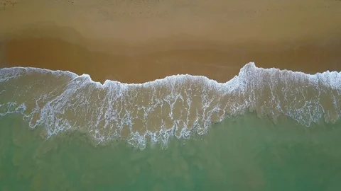 Aerial view of looping ocean wave reaching the coastline. Summer tropical beach Stock-Footage 91087775