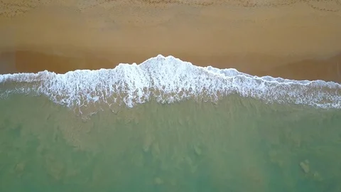 Aerial view of looping ocean wave reaching the coastline. Summer tropical beach Stock-Footage 91087859