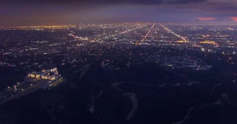 Aerial view Los Angeles cityscape night Griffith Observatory foreground. 4K UHD Stock Footage