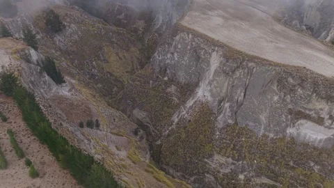 Aerial view of low hanging clouds drifting across deep canyon landscapes Stock-Footage 308406405