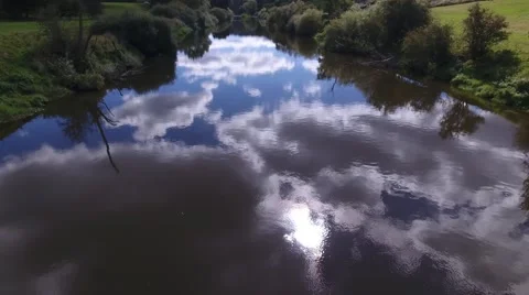 Aerial view low over a river with beautiful reflections of the sky and clouds. 動画素材 68852816