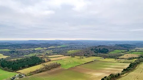 Aerial view of a lush countryside with patchwork fields and scattered trees.. Photos