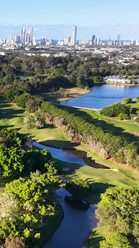 Aerial View of Lush Golf Course with Distant City Skyline 動画素材 339513534