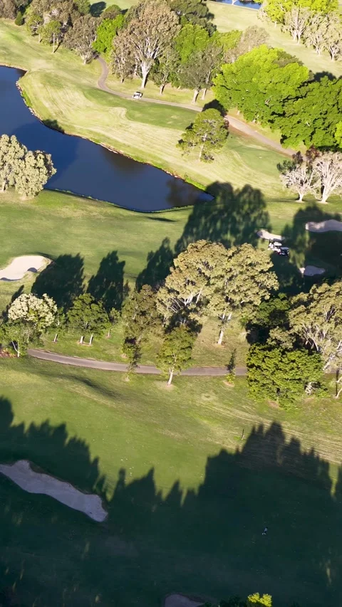 Aerial View of Lush Golf Course Fairway and Water Hazards Stock Footage 339842351