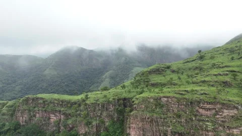 Aerial view of lush green cliffs and misty mountains at Wli Falls, Ghana 動画素材 329813432