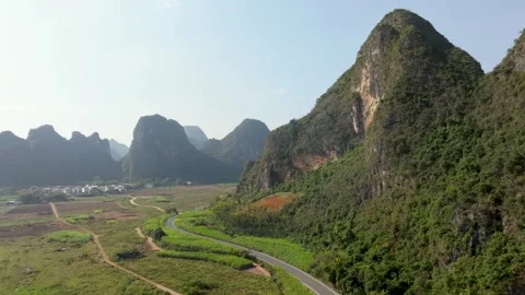 Aerial View of Lush Green Fields and Karst Mountains in Guangxi, China Stock Footage 336711339