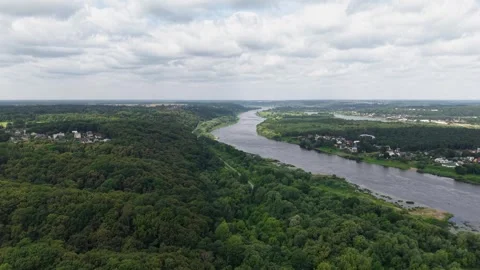Aerial View of Lush Green River Valley and Forest Under Dramatic Cloudy Sky Stock Footage 340890889