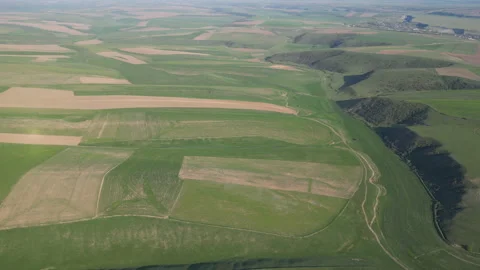 Aerial view of a lush valley featuring segmented fields and deep shadows. Stock Footage 334545268
