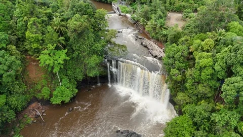 Aerial view of a lush waterfall cascading through dense green forest. Stock Footage 337990967