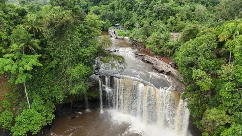 Aerial view of a lush waterfall cascading through dense green forest. Stock Footage 337991064