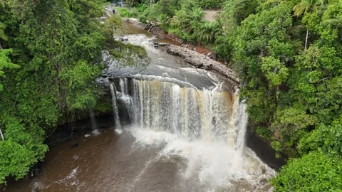 Aerial view of a lush waterfall cascading through dense green forest. Stock Footage 337991525