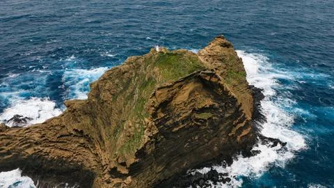 Aerial view of Madeira sea stack with white lighthouse on ridge Stock-Fotos