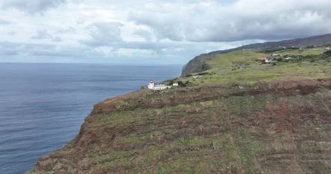Aerial view of Madeira small lighthouse along the coast and high cliffs and Stock Footage 167947953