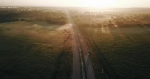 Aerial view of the main road through green meadows in fog at dawn Stock Footage 139782407