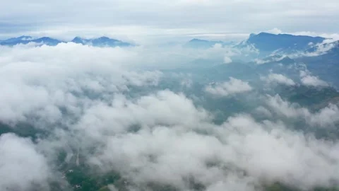 Aerial View of Majestic Mountain Range Veiled in a Flowing Sea of Clouds Stock Footage 341909855