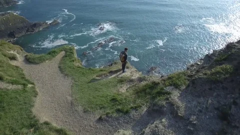 Aerial view of man with backpack on top of a cliff, Ireland Stock Footage 84271100