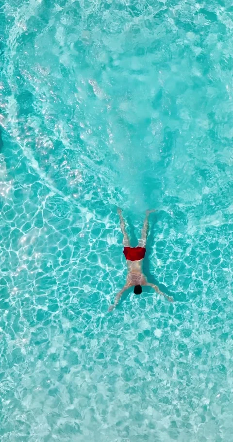 Aerial view as a man dives into the pool and swims. Slow motion Video stock 342756970