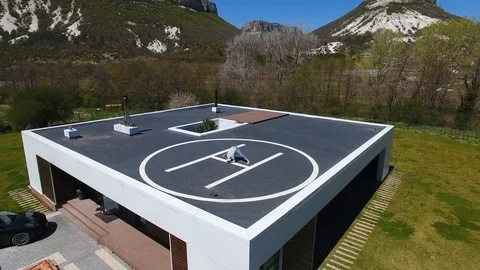 Aerial view. Man doing workout on helipad on roof of house. Open air stretch Stock Footage 129559761