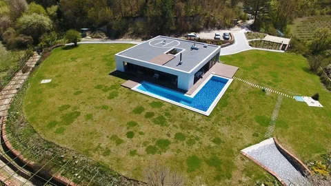 Aerial view. Man doing workout on helipad on roof of house. Open air stretch Stock Footage 129691667