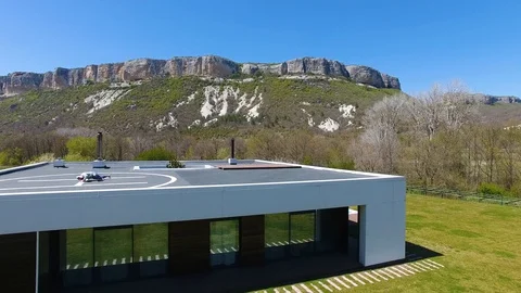 Aerial view. Man doing workout on helipad on roof of house. Open air stretch Stock Footage 129961558