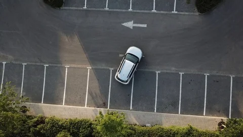 Aerial view of a man getting out of a car after parking it in reverse Stock Footage 88677789