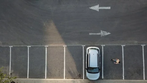 Aerial view of a man getting into a parked car, reverses it and drives away 스톡 동영상 88677507