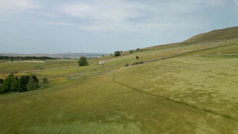 Aerial view of a man hiking through the Yorkshire Dales Stock Footage 253554257