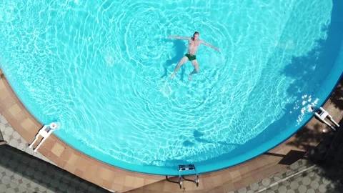 Aerial view of a man jumping and swimming in the pool. Stock-Footage 244641776