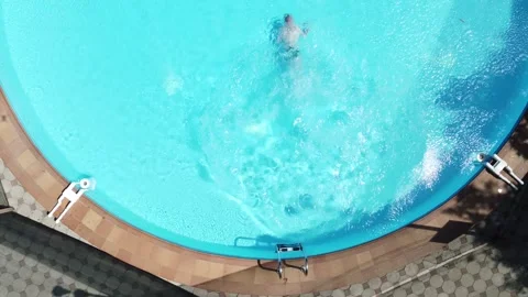 Aerial view of a man jumping and swimming in the pool. Stock-Footage 244641804
