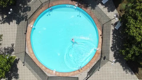Aerial view of a man jumping and swimming in the pool. Stock-Footage 244642103