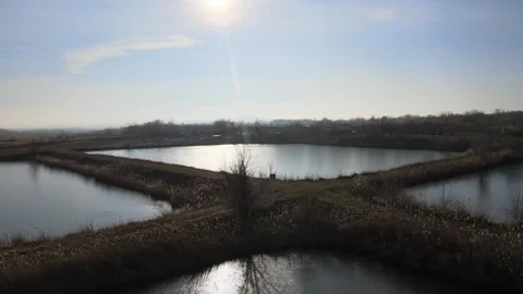 Aerial view of man-made fish farming ponds at sunset Stock Footage 337998119