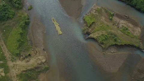 Aerial view of a man paddling down a river on a raft in Myanmar Video stock 95670514
