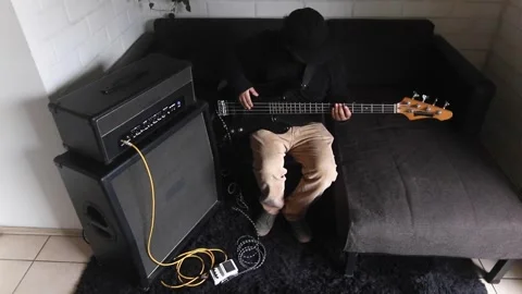 Aerial view of a man playing and practicing on his electric bass 動画素材 345087219